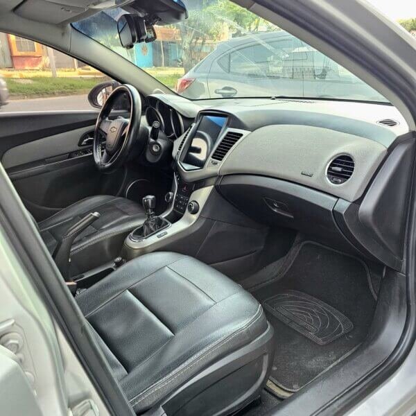 Interior del Chevrolet Cruze LS 2012 con asientos de cuero negro y tablero moderno.